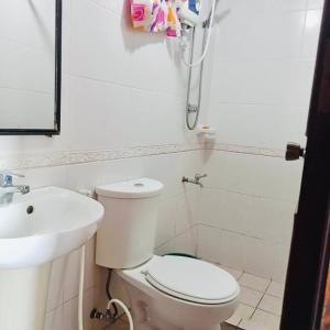 a white bathroom with a toilet and a sink at Isabelle Garden Villas 517 in Manila