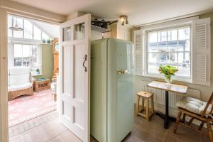 a green refrigerator in a room with a table and windows at Lantern Cottage in Stowmarket