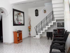 Habitación con una escalera con sillas y TV. en Mirissa Harbour View, en Mirissa