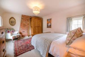a bedroom with a bed and a chair at Lantern Cottage in Stowmarket