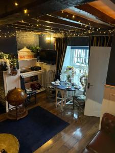 a living room with a table and a kitchen at 8 Opera Suites, Llangollen in Llangollen