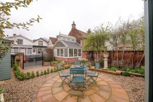 a patio with a table and chairs in a yard at Lantern Cottage in Stowmarket