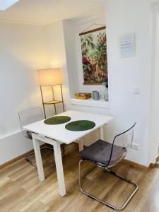 einen weißen Tisch und zwei Stühle in einem Zimmer in der Unterkunft Köln City Apartments in Köln