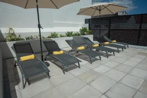 a row of chairs with umbrellas on a patio at Olive Boutique Guesthouse in Vila Franca do Campo
