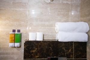 阿姆利則的住宿－Sagar Hotel JUST 5 MIN FROM GOLDEN TEMPLE，浴室的台面上堆着毛巾