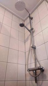 a shower with a shower head in a bathroom at Vakantiehuis Hollum Ameland dichtbij strand en met ruime tuin - Ameland39 nl in Hollum
