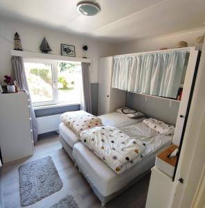 霍勒姆的住宿－Vakantiehuis Hollum Ameland dichtbij strand en met ruime tuin - Ameland39 nl，一间卧室设有两张床和大窗户