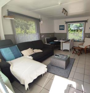 a living room with a couch and a table at Vakantiehuis Hollum Ameland dichtbij strand en met ruime tuin - Ameland39 nl in Hollum