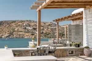 a patio with chairs and a view of the ocean at Porto Dema Luxury Suites in Schinoussa