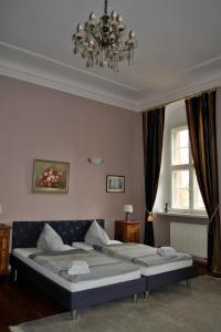 1 dormitorio con 2 camas y lámpara de araña en Schloss Triestewitz, en Arzberg
