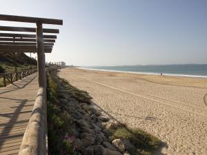 エル・プエルト・デ・サンタマリアにあるLightbooking Ancora Cádizの海辺の浜辺に座るベンチ