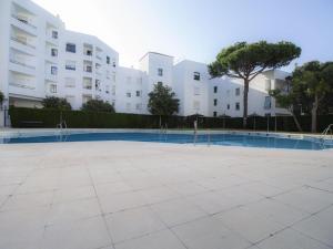 a swimming pool in front of a building at Lightbooking Ancora Cádiz in El Puerto de Santa María