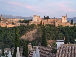 a view of a castle on a hill with roofs at Lightbooking El Realejo Granada in Granada