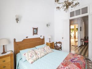 1 dormitorio con cama y lámpara de araña en Lightbooking Patio tipico canario Hermigua en Hermigua