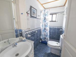 a blue and white bathroom with a sink and a toilet at Lightbooking Patio tipico canario Hermigua in Hermigua
