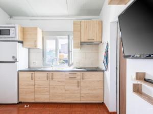 una cocina con armarios de madera y fregadero en Lightbooking El Remo, en El Remo