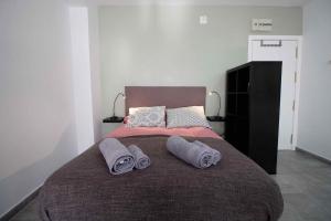 a bedroom with a large bed with two towels on it at Lightbooking Estadio Cádiz in Cádiz