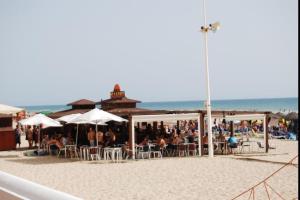 加的斯的住宿－Lightbooking Estadio Cádiz，一群人坐在沙滩上的椅子上