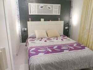 1 dormitorio con 1 cama grande con manta morada en Lightbooking Vejer de la Frontera, en Vejer de la Frontera