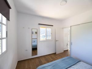 1 dormitorio con paredes blancas y espejo en Lightbooking Hermigua Juan y Fina II, en Hermigua