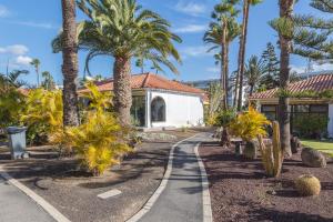 a walkway in front of a house with palm trees at Lightbooking Sun Club deluxe Playa del Ingles in Playa del Ingles