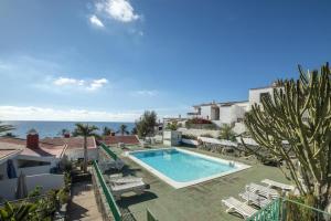 a swimming pool with a view of the ocean at Lightbooking Aguila Beach San Agustin in Maspalomas