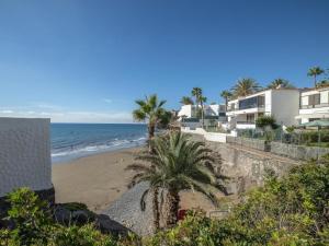 a view of a beach with palm trees and houses at Lightbooking Aguila Beach San Agustin in Maspalomas