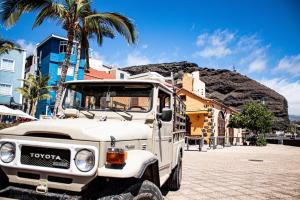 Un camión blanco estacionado en una calle con una montaña. en Lightbooking Tazacorte La Palma, en Tazacorte
