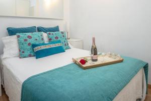 a bed with a tray of food and a bottle of wine at Lightbooking Canteras Beach in Las Palmas de Gran Canaria