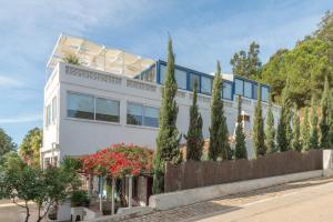 una casa blanca con árboles delante de ella en Lightbooking Praia Fabrica Algarve, en Vila Nova de Cacela