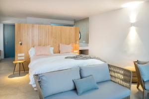 テルデにあるLightbooking Edem Playa del Hombreのベッドルーム(大型ベッド1台、青いソファ付)