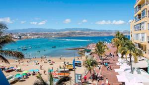 ラスパルマス・デ・グランカナリアにあるLightbooking Las Palmas Canteras Beachの人々と海の群れを持つ海岸