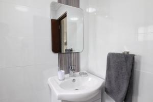 a white bathroom with a sink and a mirror at San Lameer Villa 2505 by Top Destinations Rentals in Southbroom