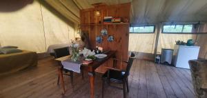 een kamer met een tafel en stoelen in een tent bij Luxe tent op het platteland in Nieuwediep