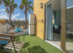 a patio with a refrigerator and a table and chairs at Lightbooking Oasis Royal Corralejo in Corralejo