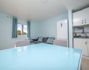 a kitchen and living room with a table and a couch at Lightbooking Oasis Royal Corralejo in Corralejo