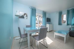 a blue living room with a table and chairs at Lightbooking Oasis Royal Corralejo in Corralejo