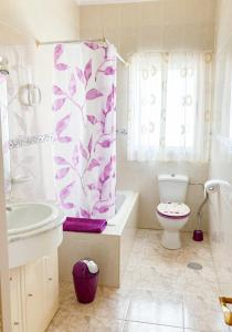 a bathroom with a toilet and a shower curtain at Lightbooking Aloe Las Playitas Beach in Las Playitas