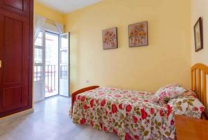 a bedroom with a bed with a red and white blanket at Lightbooking Mazarredo San Fernando in San Fernando