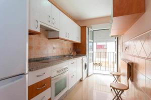 a kitchen with white cabinets and a stove top oven at Lightbooking Mazarredo San Fernando in San Fernando