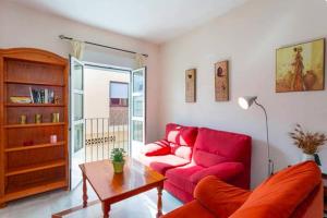 sala de estar con sofá rojo y mesa en Lightbooking Mazarredo San Fernando en San Fernando