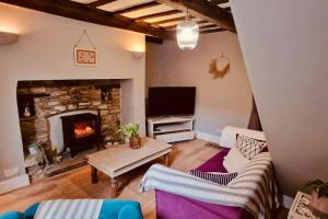a living room with a couch and a fireplace at Hideaway Cottage Sleaford in Sleaford