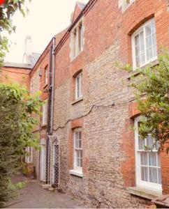 an old brick building with white windows on a street at Hideaway Cottage Sleaford in Sleaford