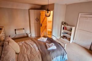 a bedroom with a bed with two towels on it at Hideaway Cottage Sleaford in Sleaford