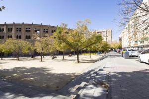 a city street with trees in front of a building at Lightbooking Plaza de Toros Granada in Granada