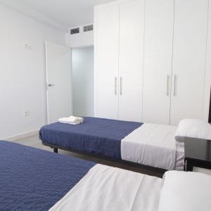 a bedroom with two beds and white cabinets at Lightbooking Plaza de Toros Granada in Granada