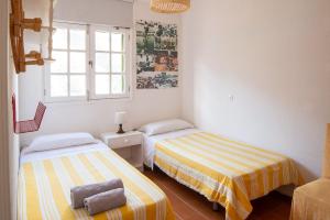 アガエテにあるCasa Carmen Agaete Vista al Marのベッドルーム1室(ベッド2台、窓付)