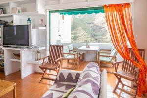 un soggiorno con divano, tavolo e TV di Casa Carmen Agaete Vista al Mar ad Agaete