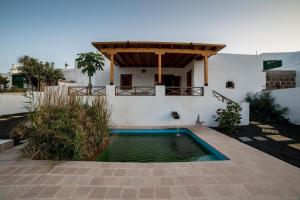 une maison avec une piscine dans la cour dans l'établissement Lightbooking Haría Lanzarote, à Haría