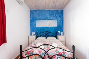 a bedroom with a bed with a blue wall at Lightbooking La Hoya Tenerife in Güimar